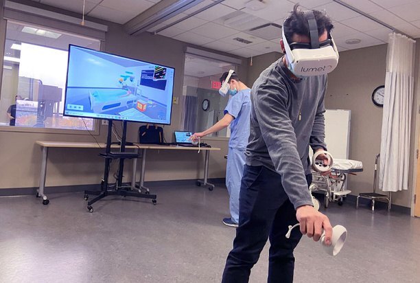 Learner in a headset with the session cast to a screen